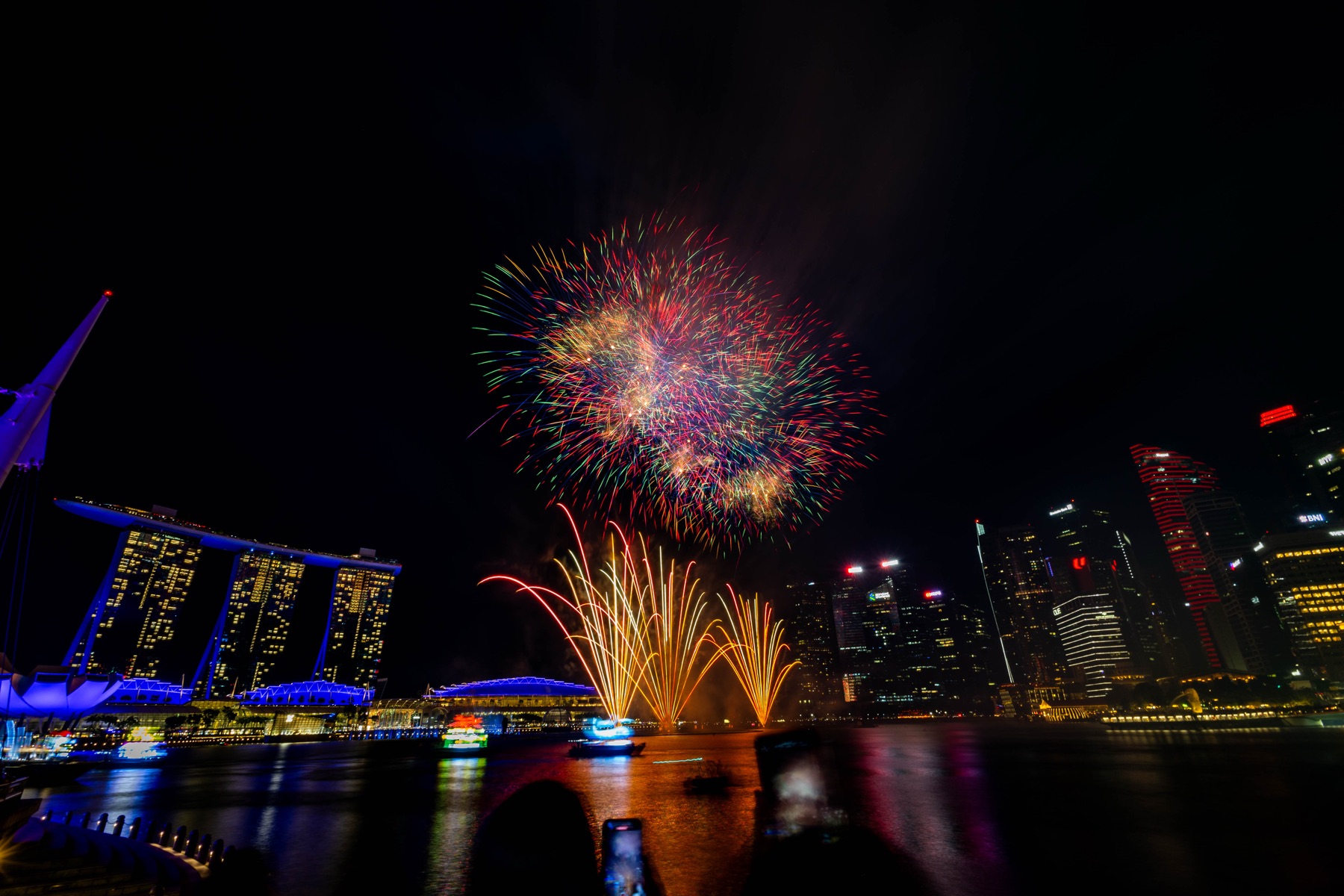 Colourful fireworks above the Marina Bay skyline at night.