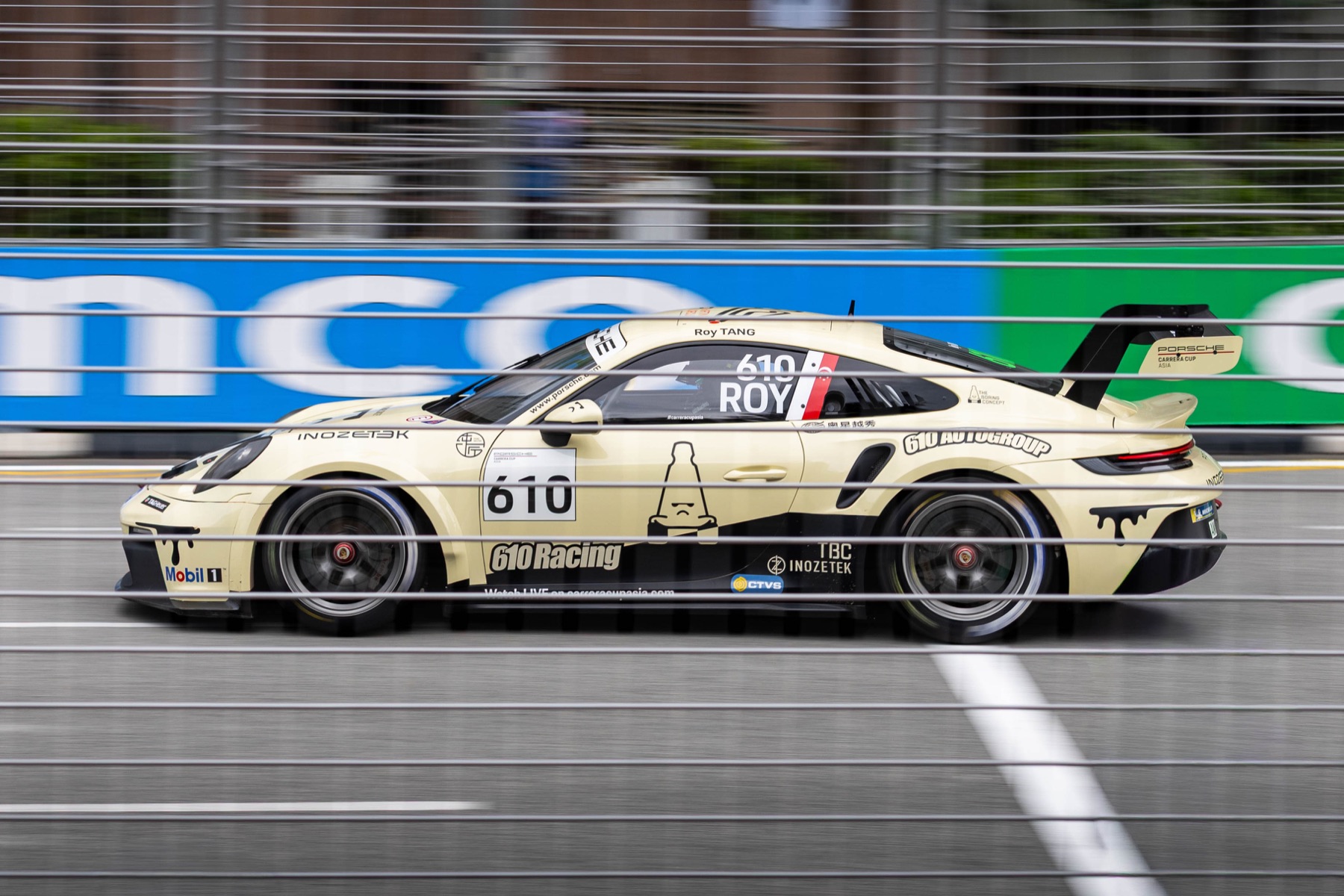 A Porsche racing car photographed in motion on a circuit.